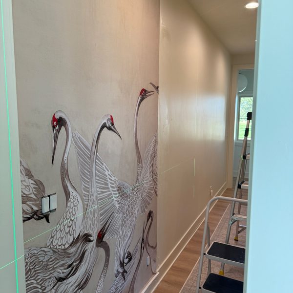 Hand-painted crane mural installed on a hallway wall